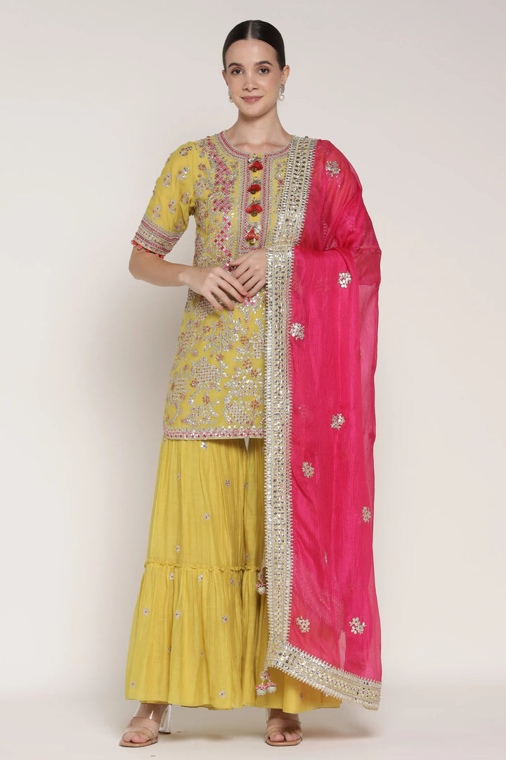 Woman wearing a yellow and pink traditional outfit with a white background