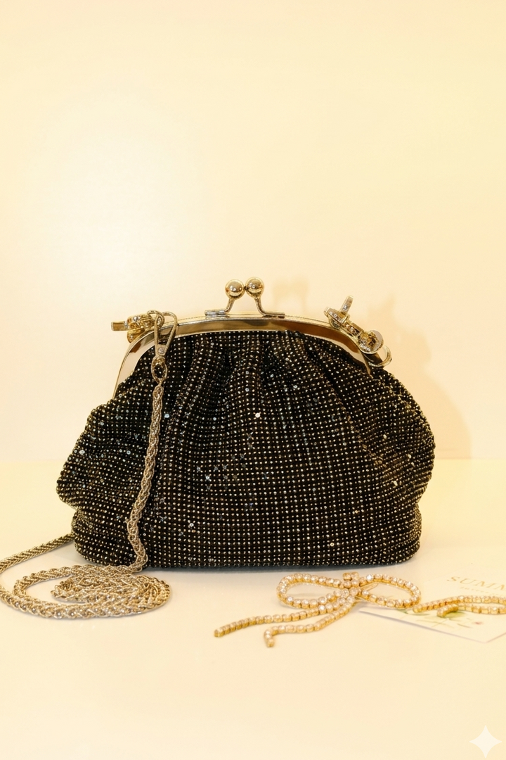 Black beaded handbag with gold chain on a light beige background