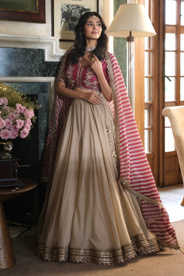 Woman in a traditional outfit standing in a room with decorative elements.