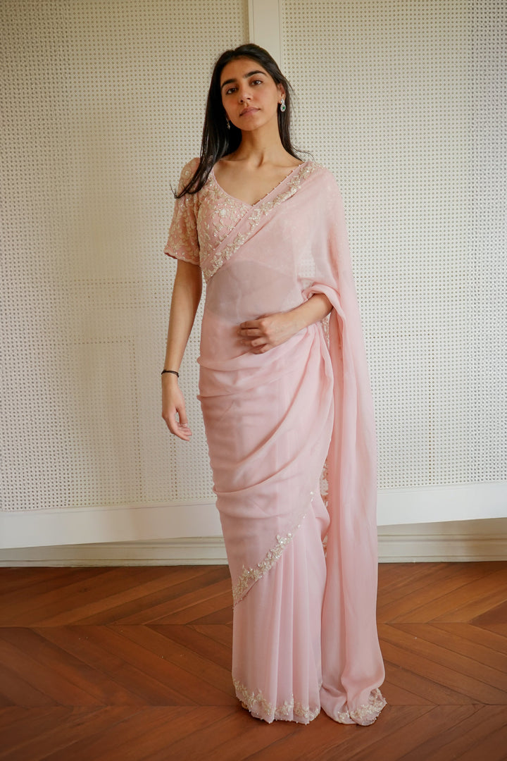 Woman wearing a pink saree with a white background