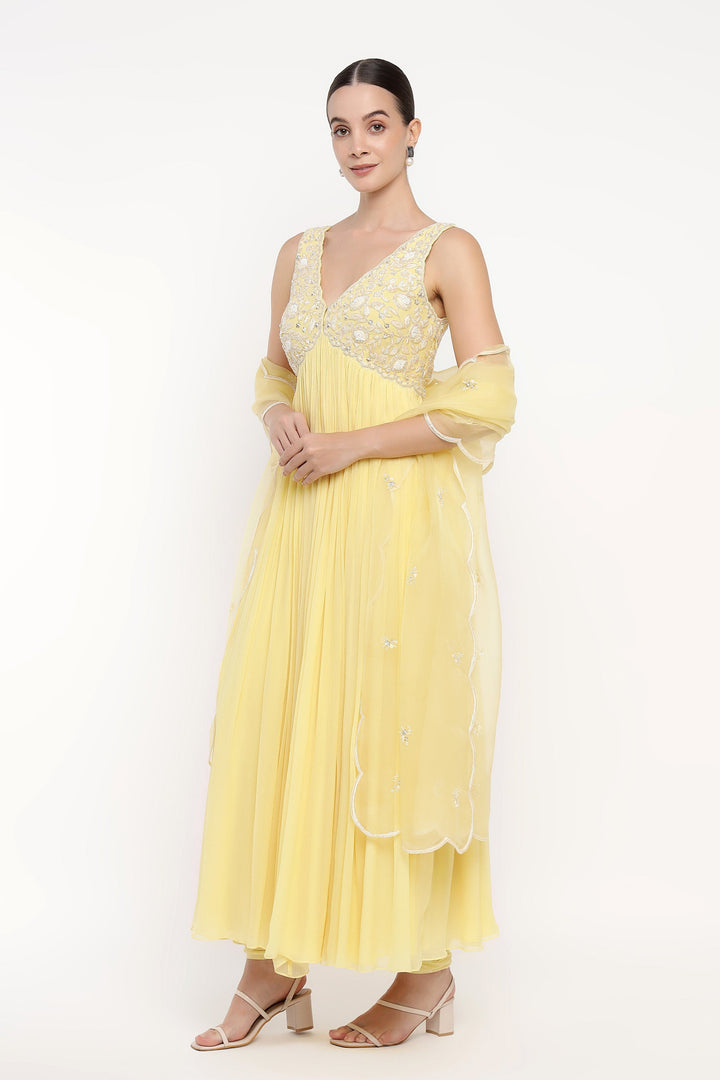 Woman wearing a yellow dress with floral patterns on a white background