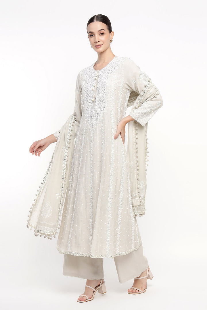 Woman wearing a white embroidered outfit on a white background