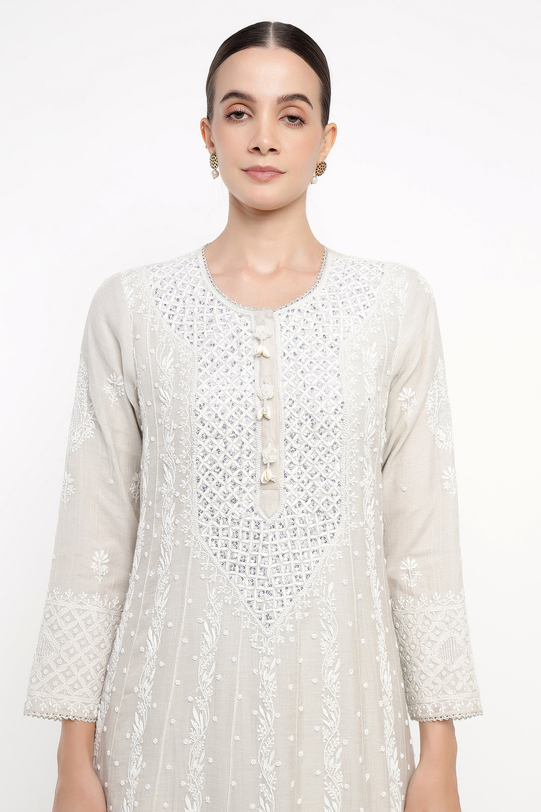 Woman wearing a white lace dress on a white background