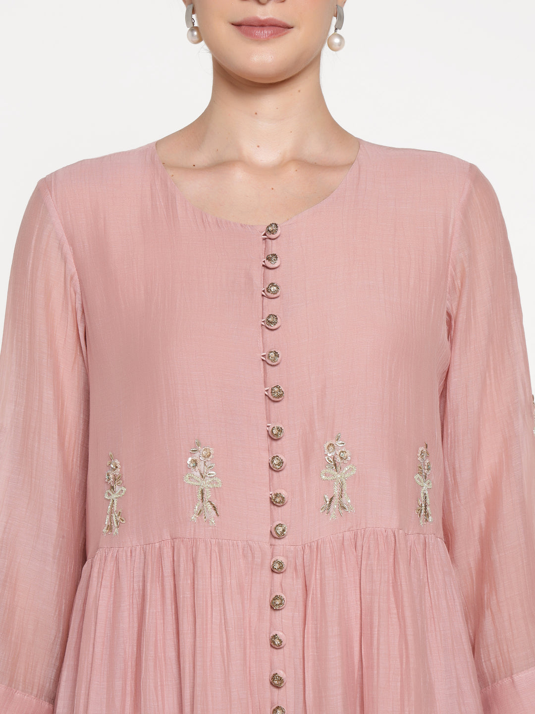 Pink dress with floral embroidery and buttons on a white background