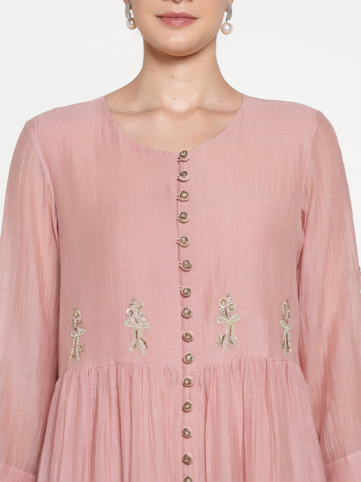 Pink dress with floral embroidery and buttons on a white background