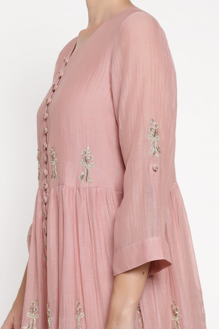Pink dress with floral embroidery on a white background