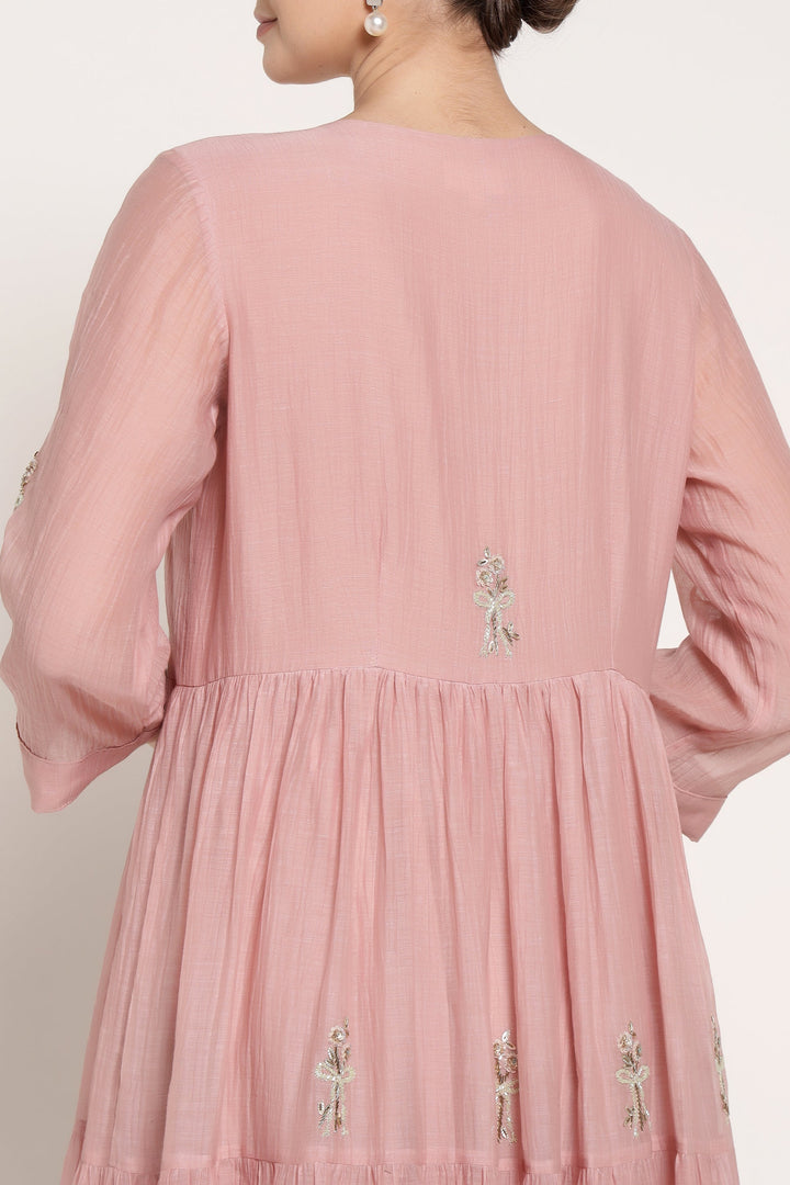 Pink dress with floral embroidery on a plain background