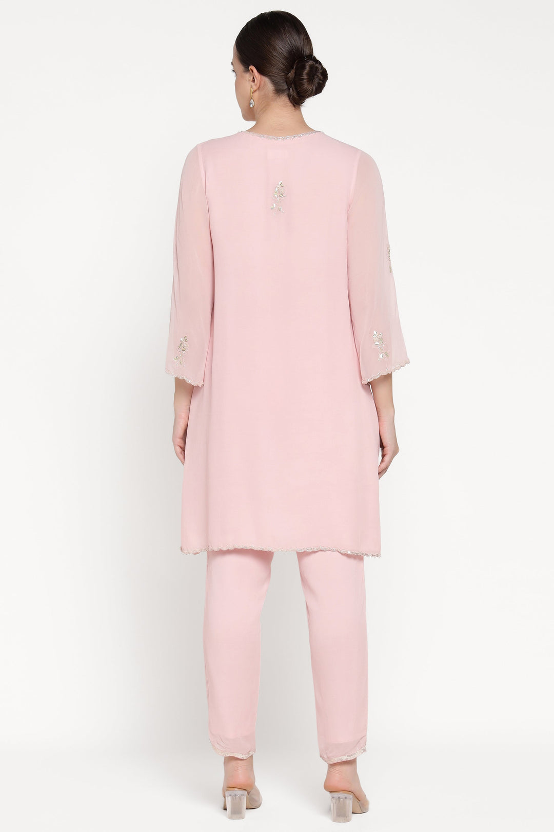 Woman wearing a light pink outfit on a white background