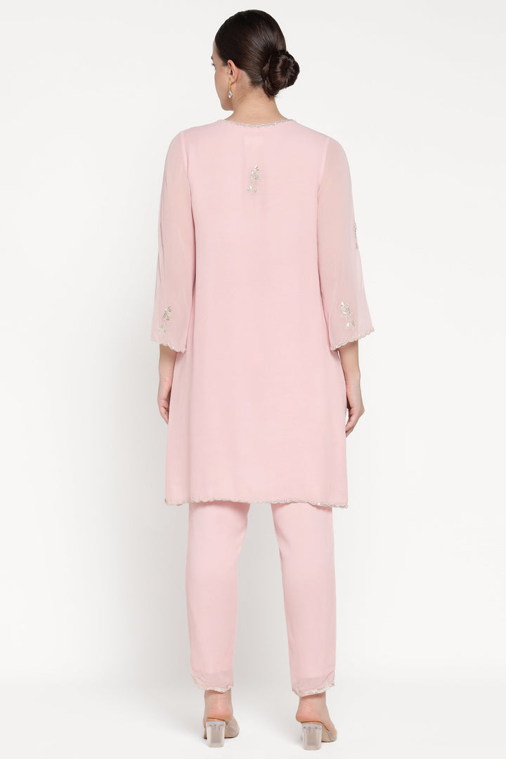 Woman wearing a light pink outfit on a white background