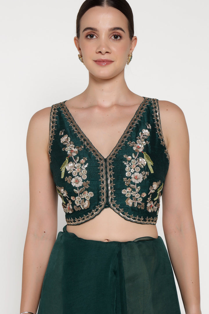 Woman wearing a green embroidered top and skirt on a white background