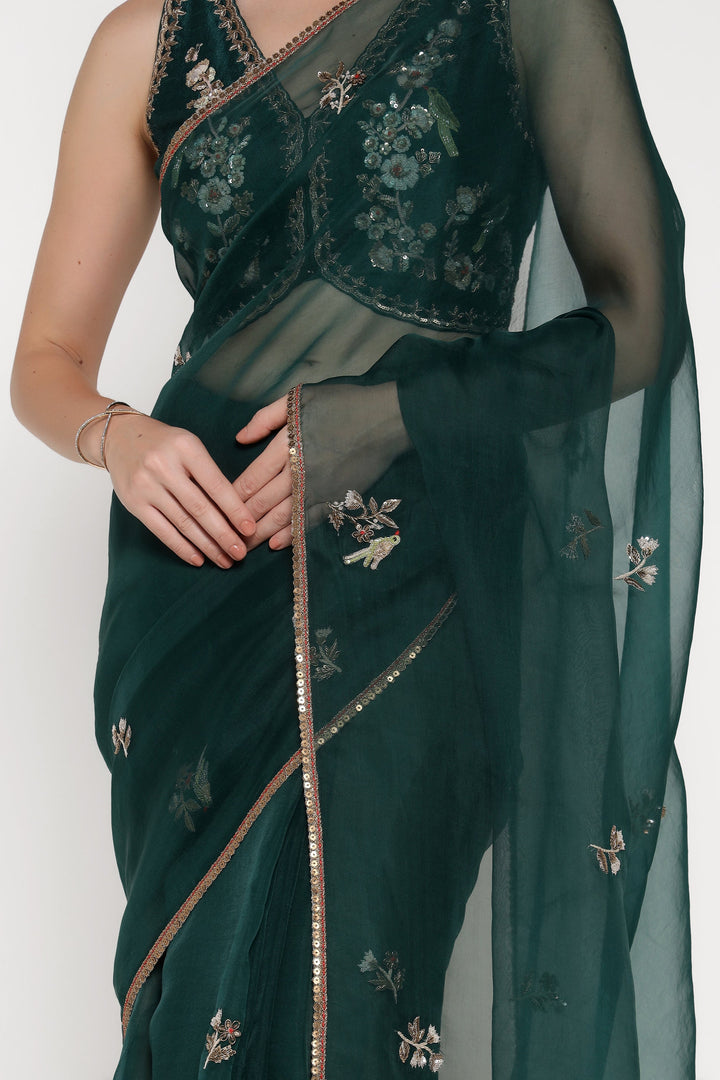 Green saree with floral embroidery on a plain background