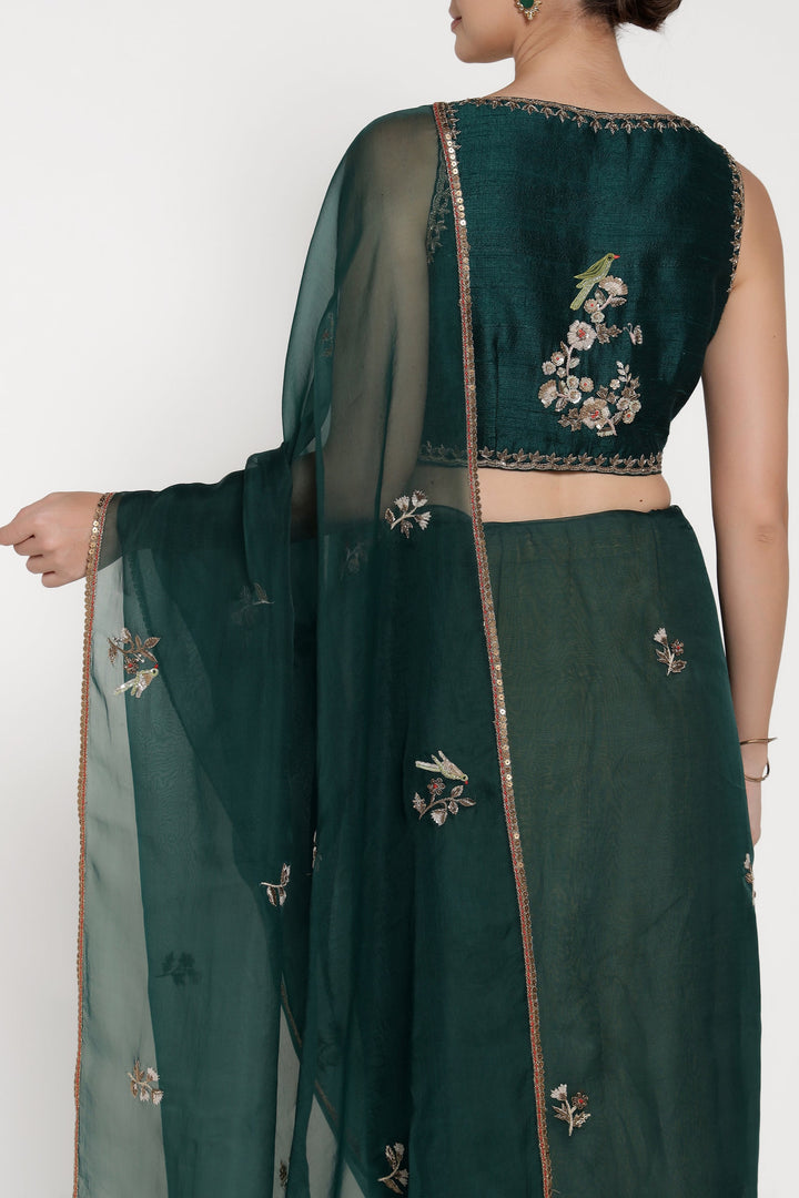 Green embroidered traditional outfit with a sheer dupatta on a white background