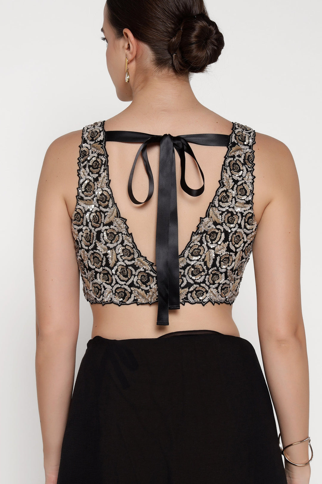 Woman wearing a black lace top with a ribbon detail on a white background