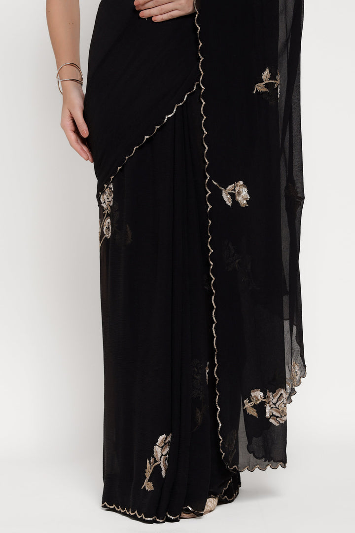 Black saree with floral embroidery on a white background