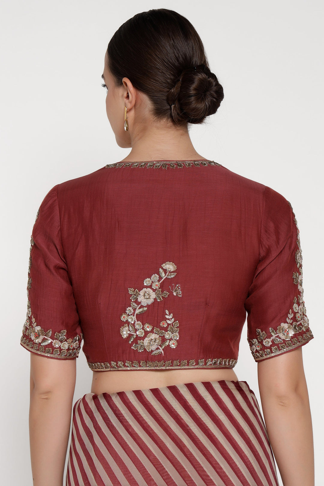 Maroon saree with floral embroidery on a plain background