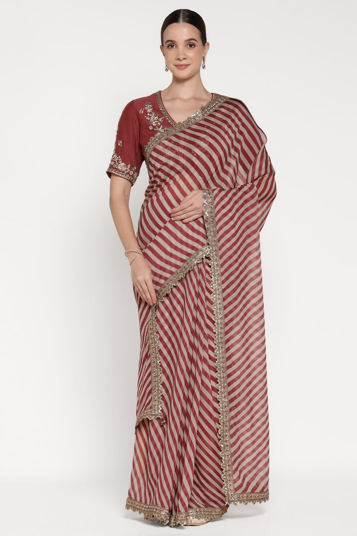 Woman wearing a red and white striped saree with gold border on a white background