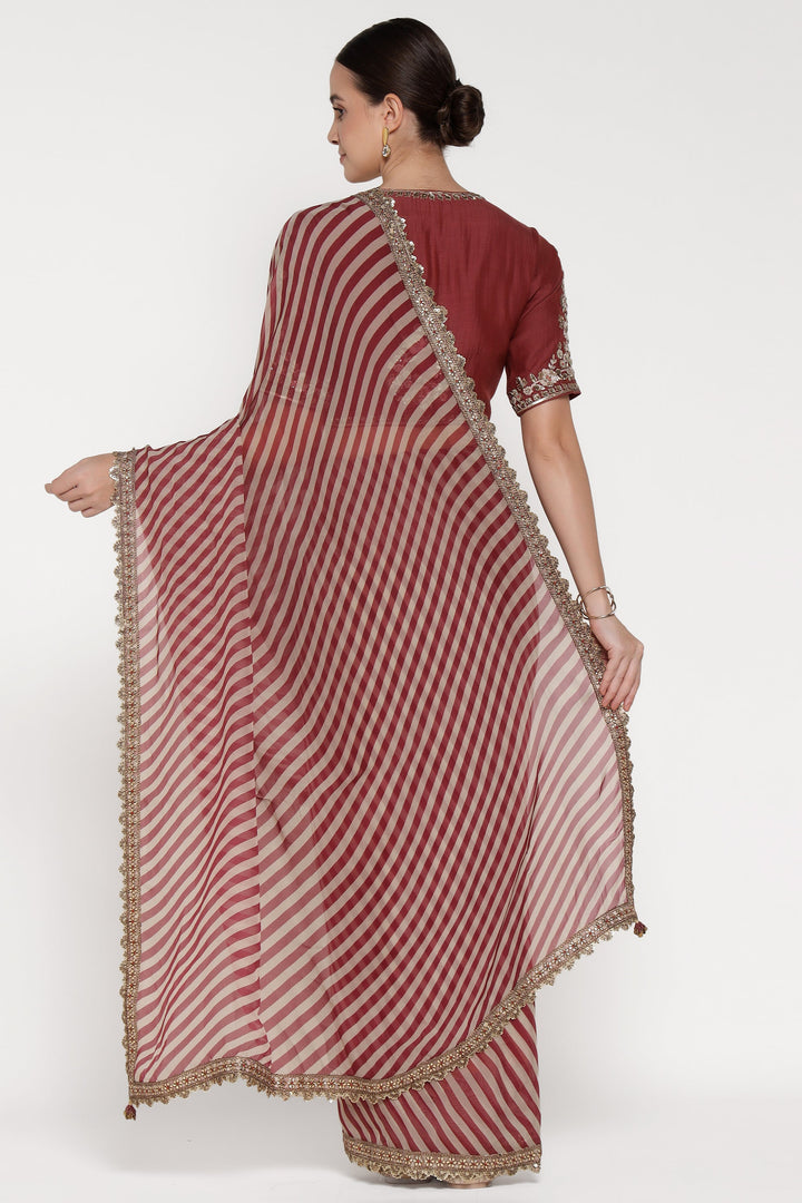 Woman wearing a red and white striped saree with gold border on a white background