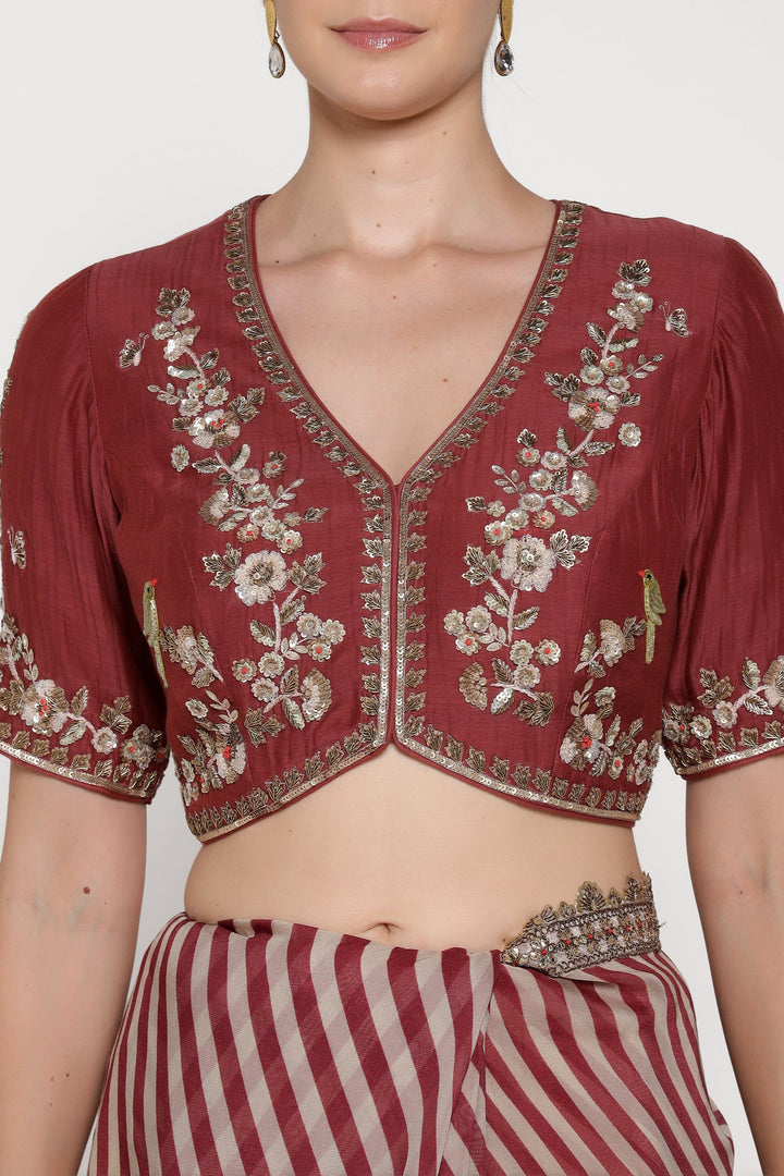 Maroon embroidered blouse with floral patterns on a plain background