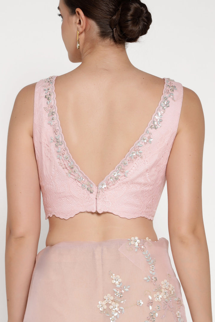 Pink embroidered blouse on a plain background
