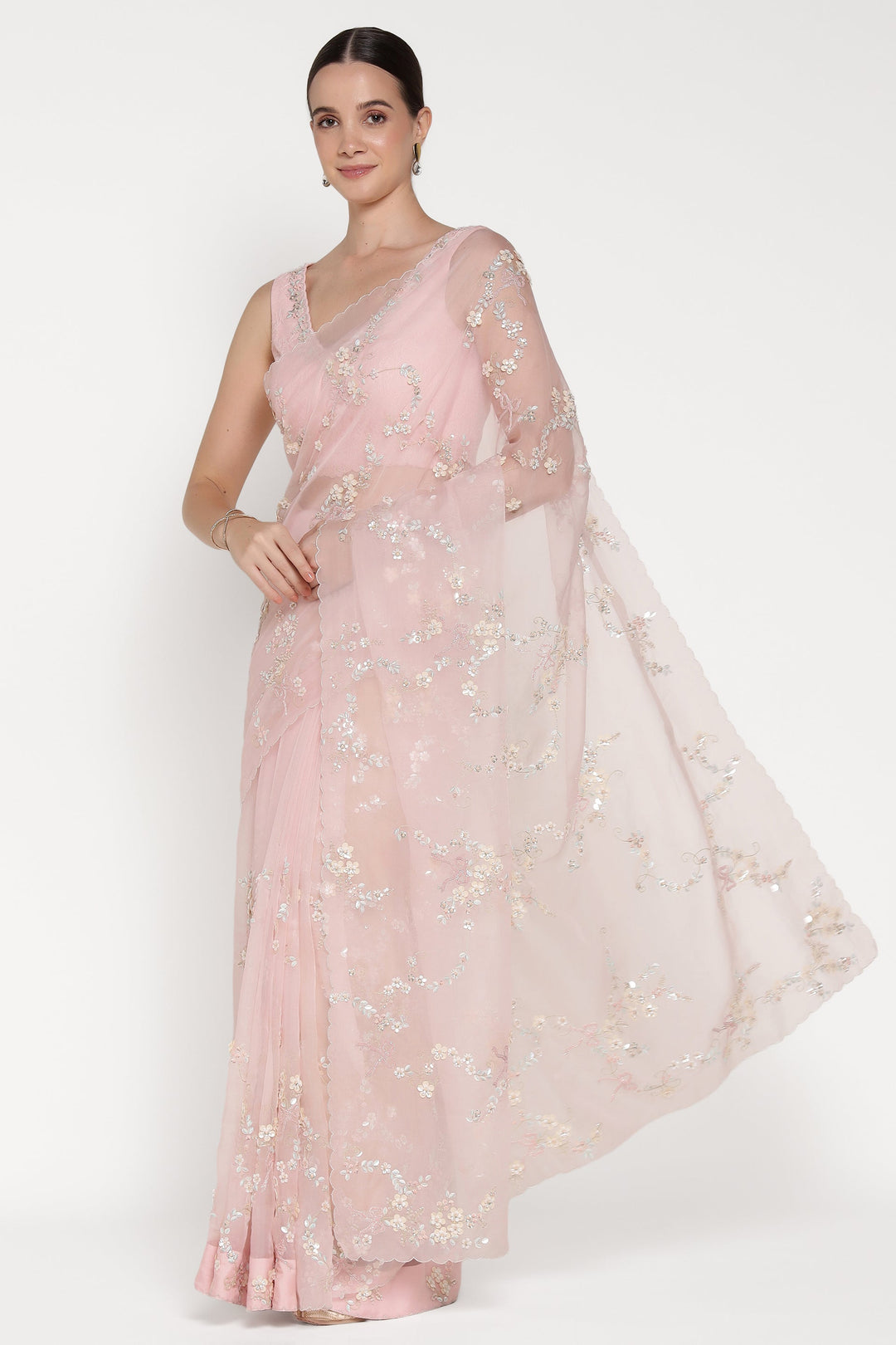 Woman wearing a pink embroidered dress on a white background