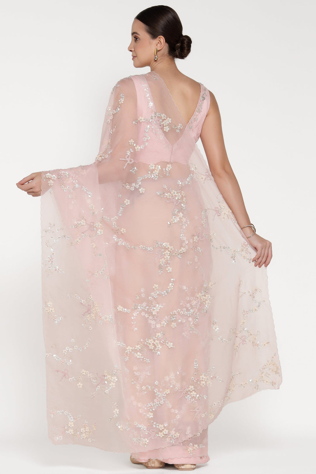 Woman wearing a light pink floral dress on a white background