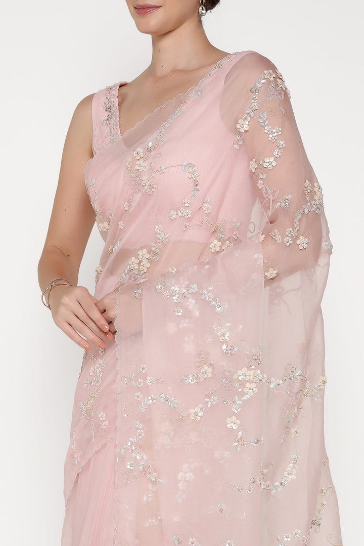 Light pink saree with floral embroidery on a plain background