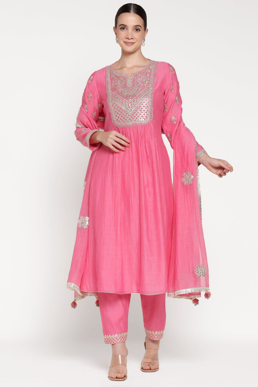 Woman wearing a pink traditional outfit with intricate designs on a white background