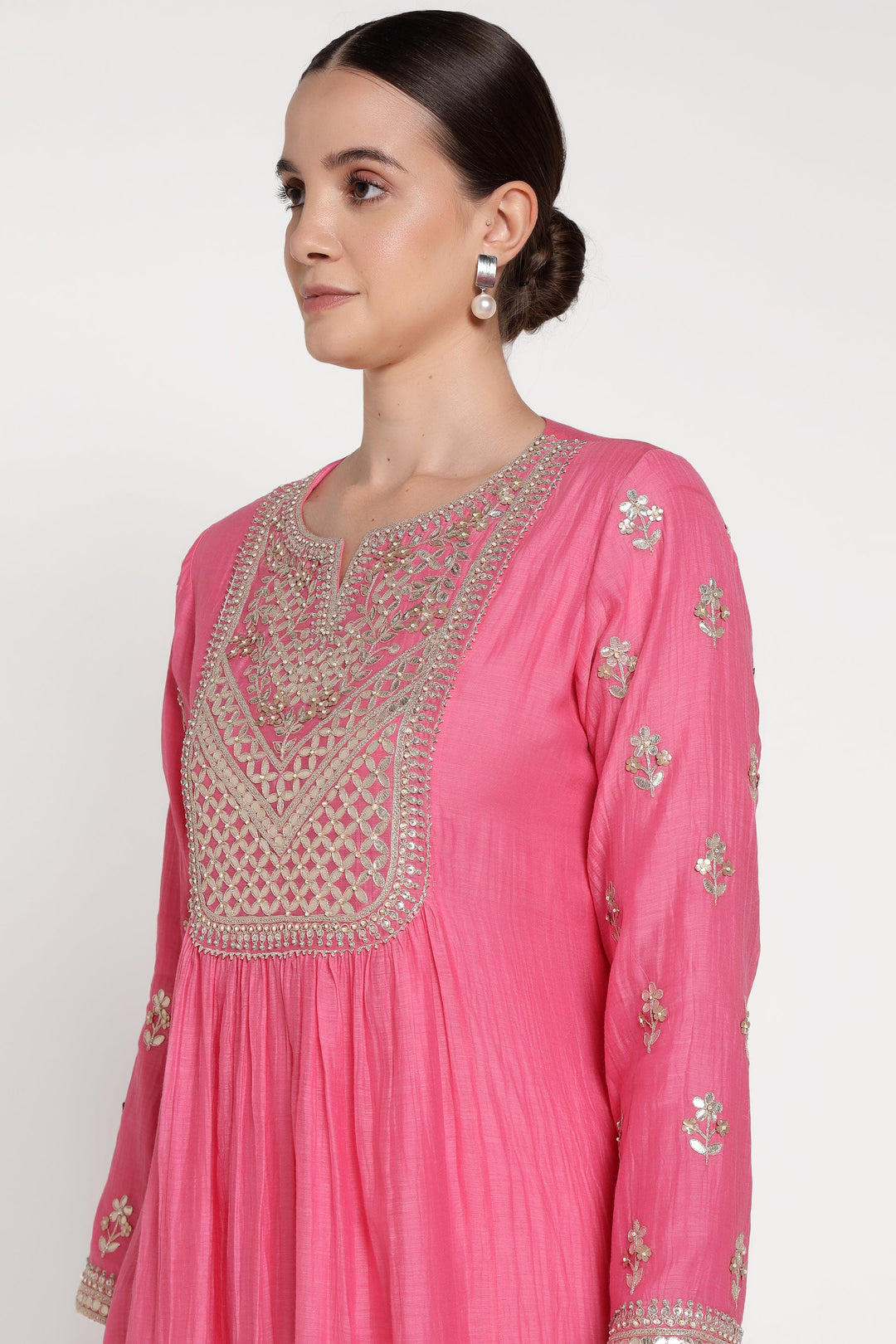 Pink traditional outfit with intricate embroidery on a white background