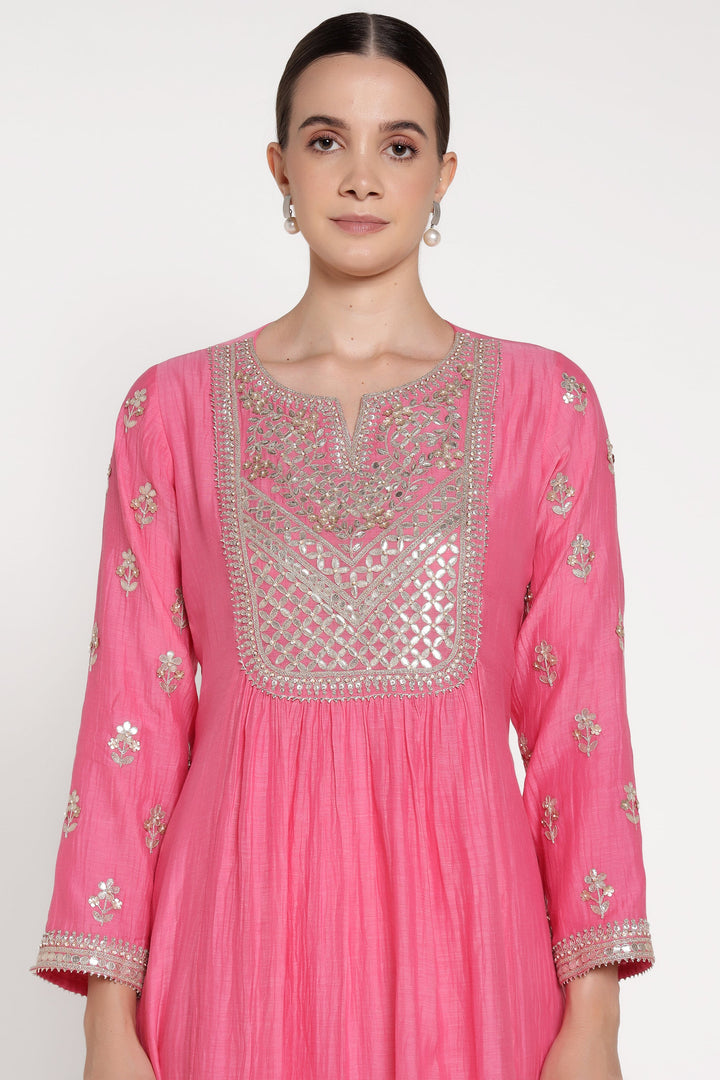 Pink traditional outfit with intricate silver embroidery on a white background