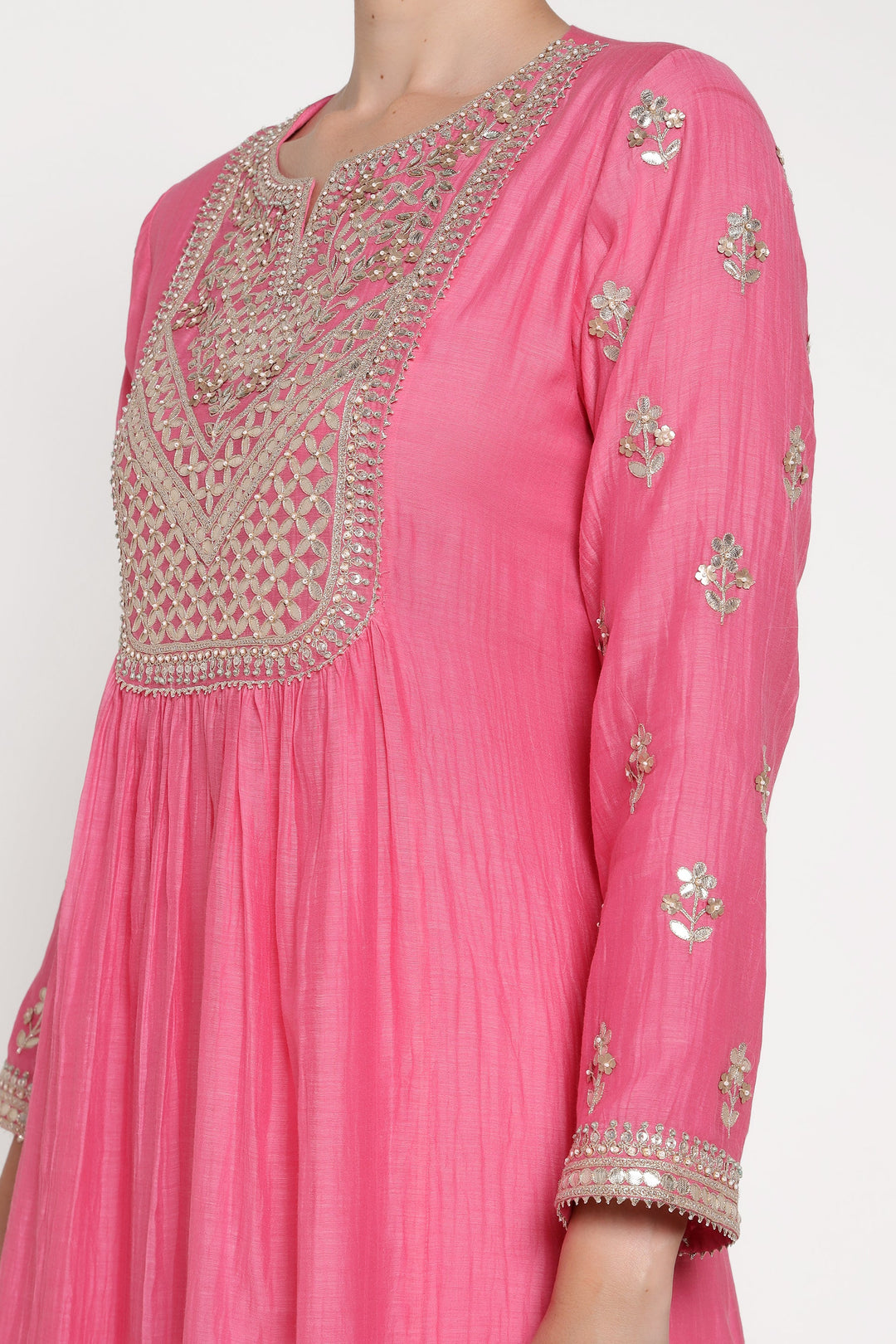 Pink traditional outfit with intricate gold embroidery on a white background