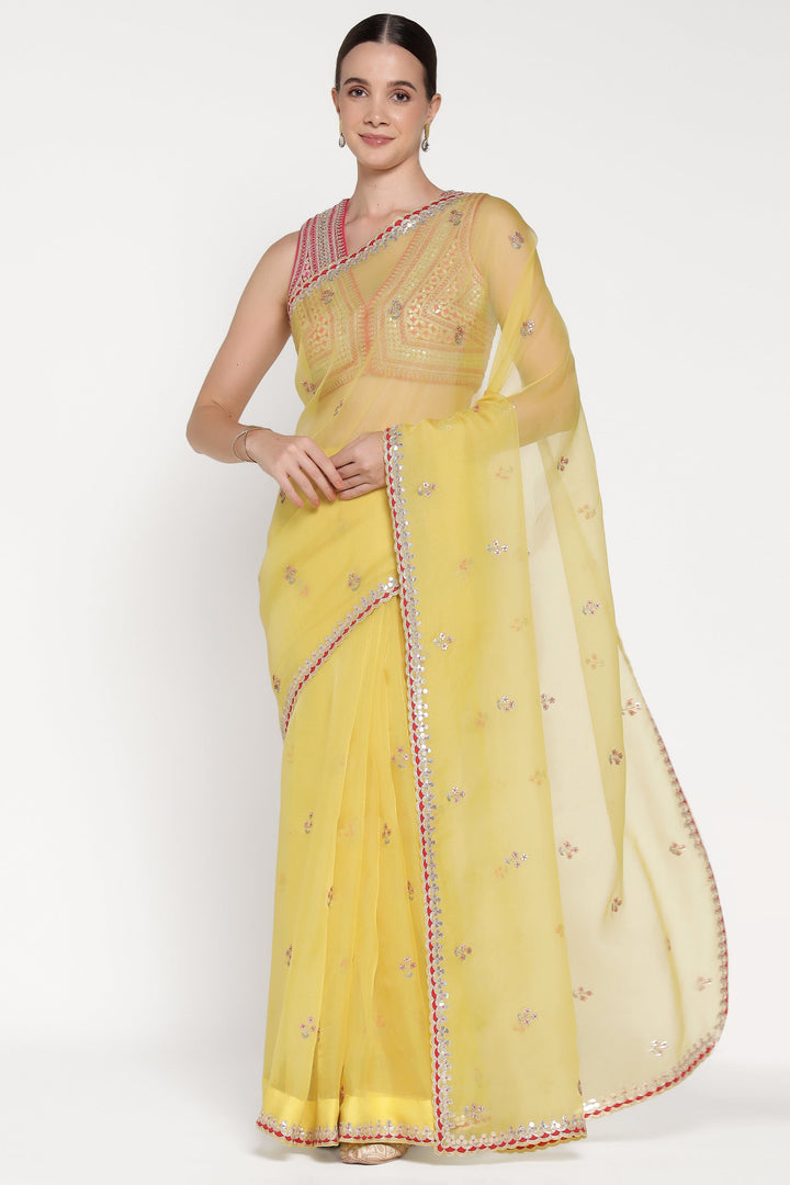 Woman wearing a yellow saree with a white background