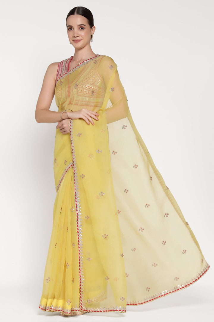 Woman wearing a yellow saree with a white background