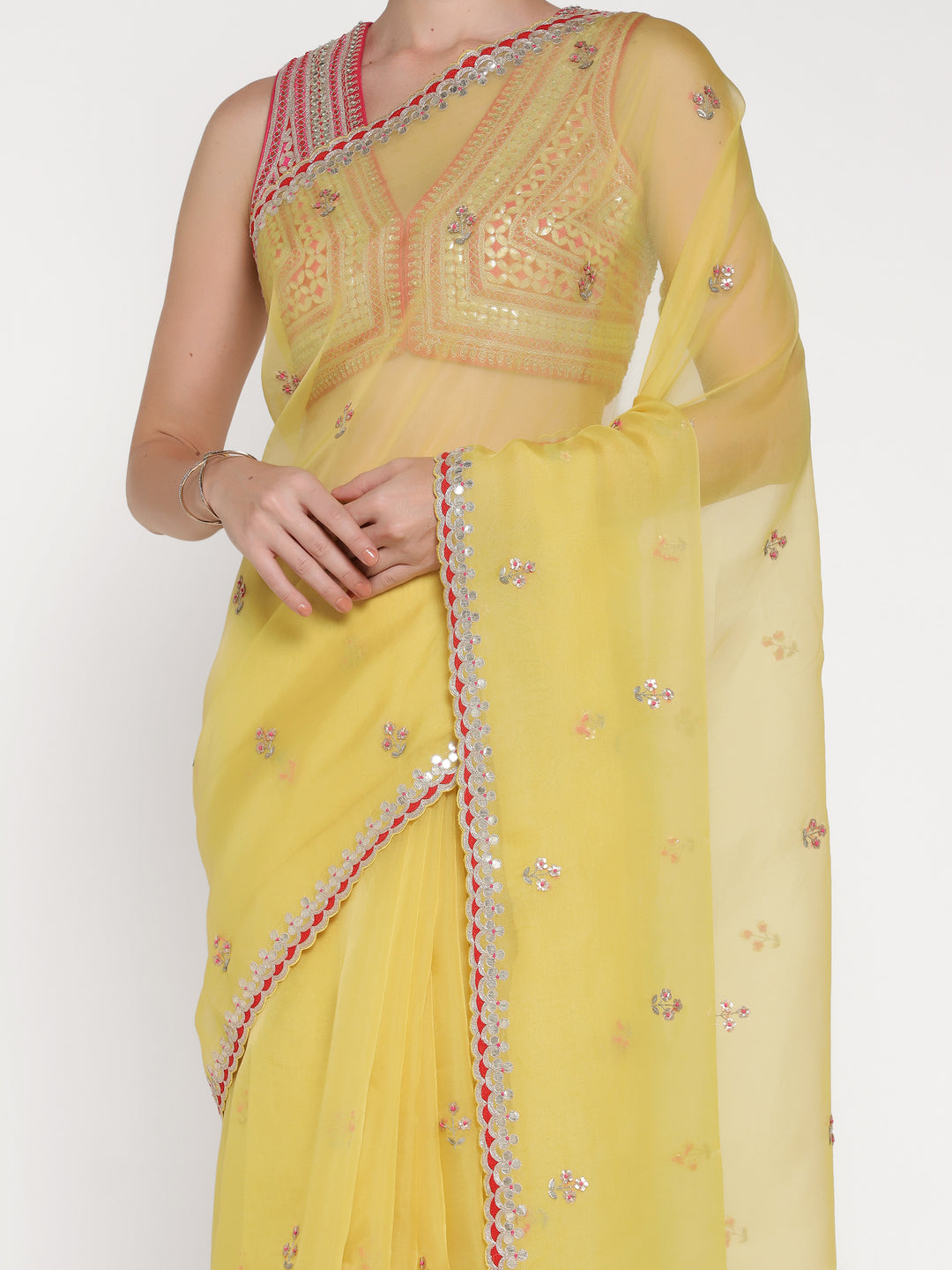 Yellow saree with intricate embroidery on a plain background