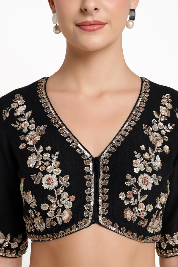 Black embroidered blouse with floral patterns on a white background