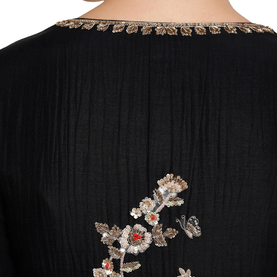 Black garment with floral embroidery on a white background