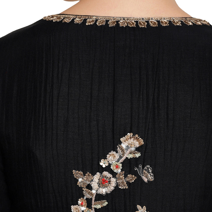 Black garment with floral embroidery on a white background