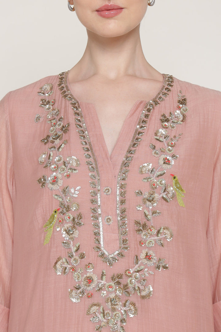Pink blouse with intricate gold embroidery on a plain background