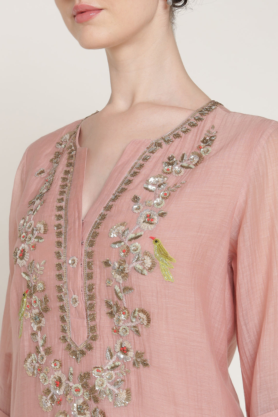 Pink embroidered garment on a plain background