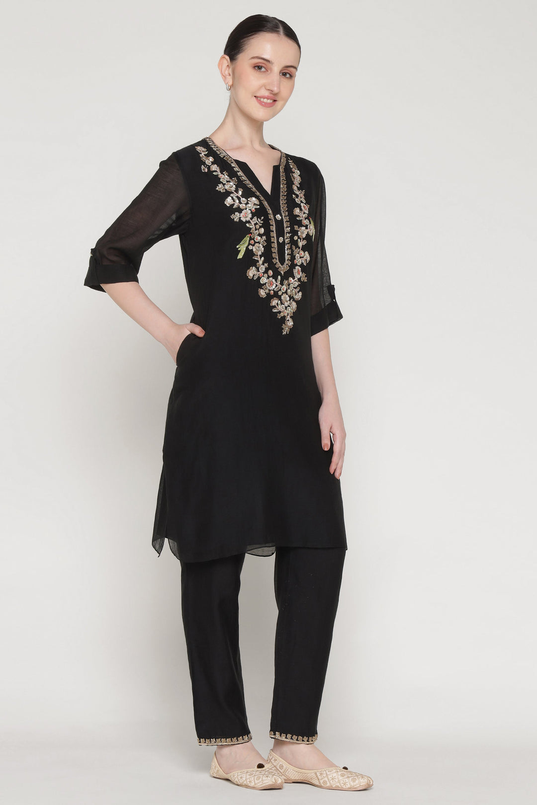Woman wearing a black embroidered kurta with pants on a white background