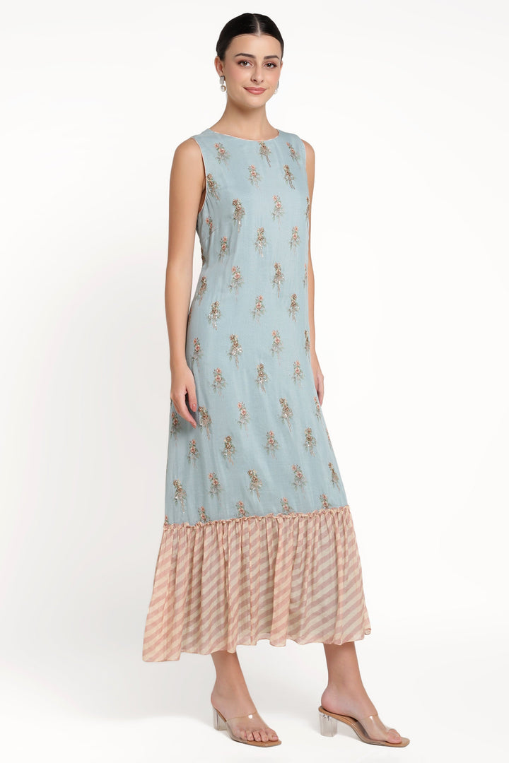 Woman wearing a light blue dress with floral patterns on a white background