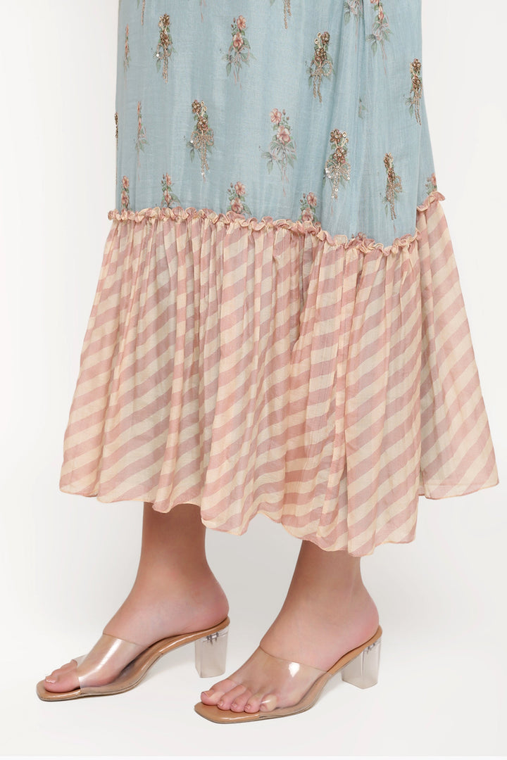Light blue dress with floral pattern and pink striped skirt worn by a person on a white background