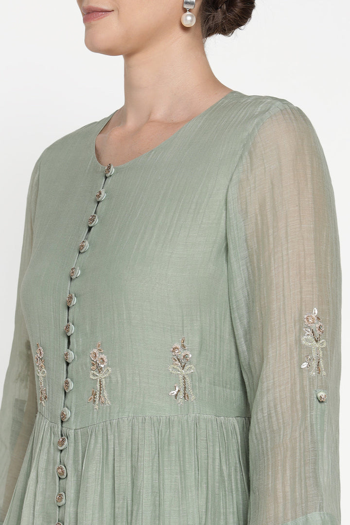 Light green dress with floral embroidery on a white background