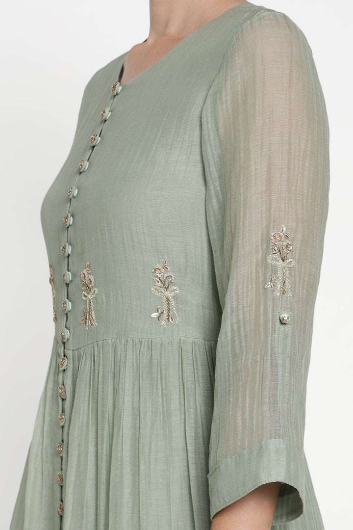 Green dress with floral embroidery on a white background