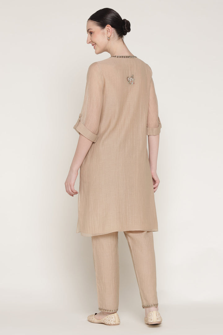 Woman wearing a beige outfit on a white background