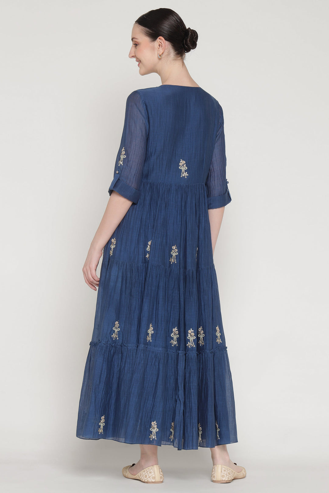 Woman wearing a blue embroidered dress on a white background