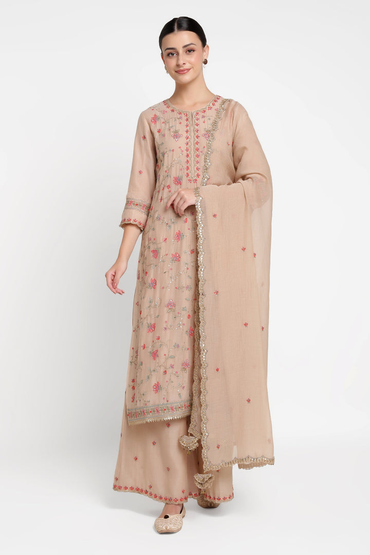 Woman wearing a beige traditional outfit with a matching dupatta on a white background