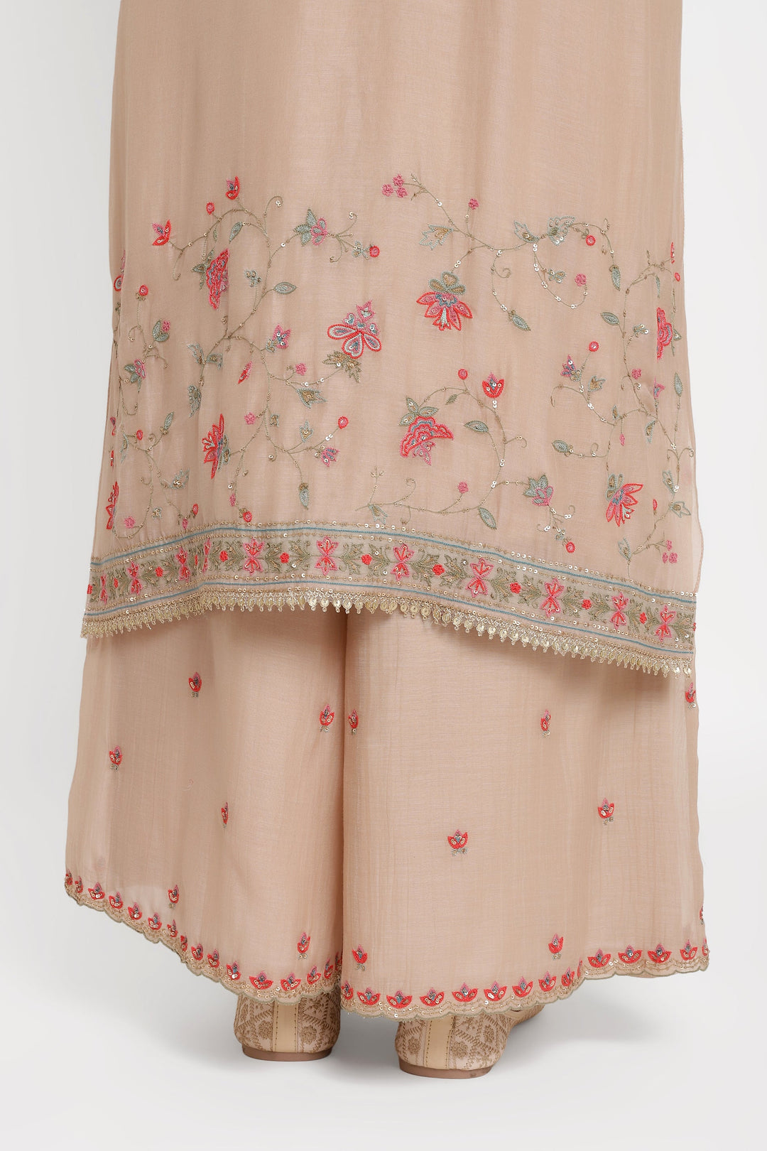 Beige traditional outfit with floral embroidery on a white background