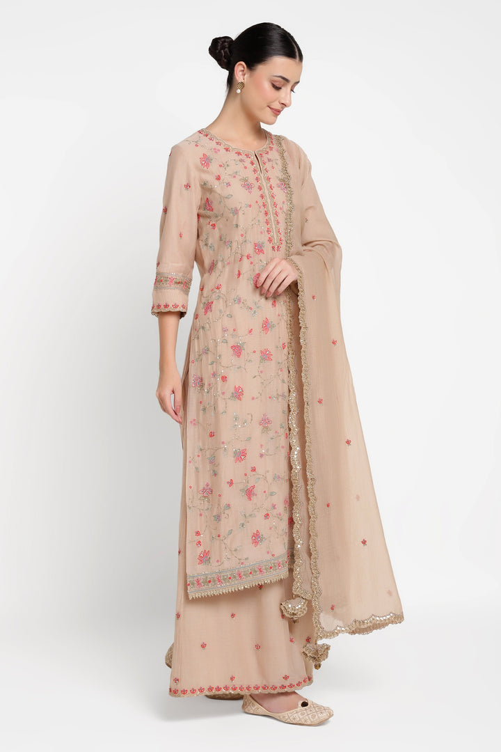 Woman wearing a beige traditional outfit with a matching dupatta on a white background