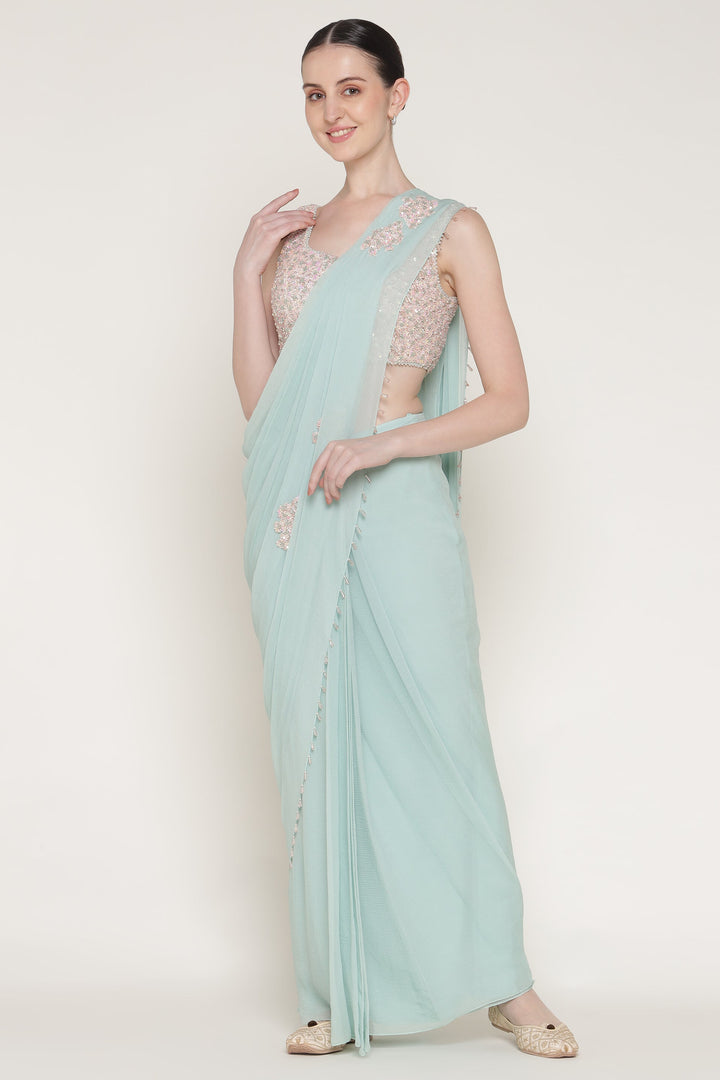 Woman wearing a light blue saree with a white background