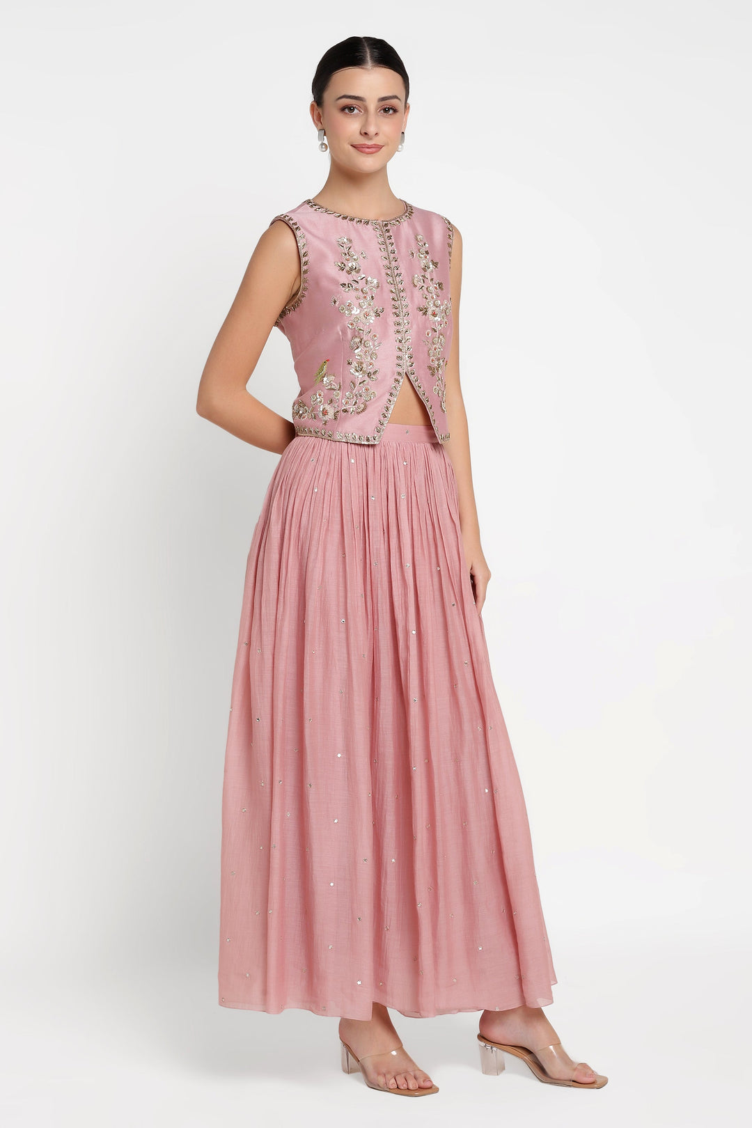 Woman wearing a pink embroidered dress on a white background